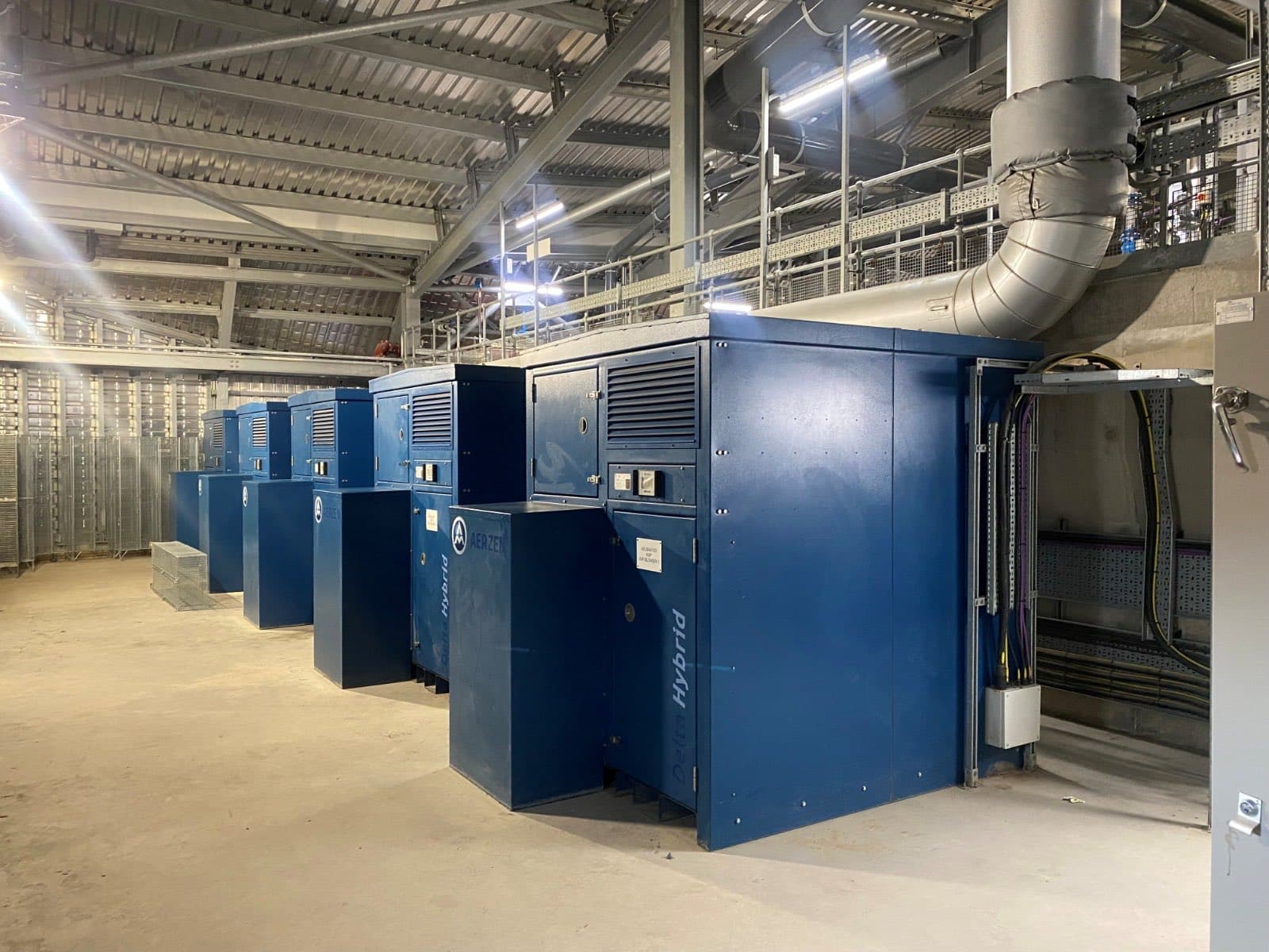 Row of Aerzen Delta Hybrid blower packages in a steel-framed plant room