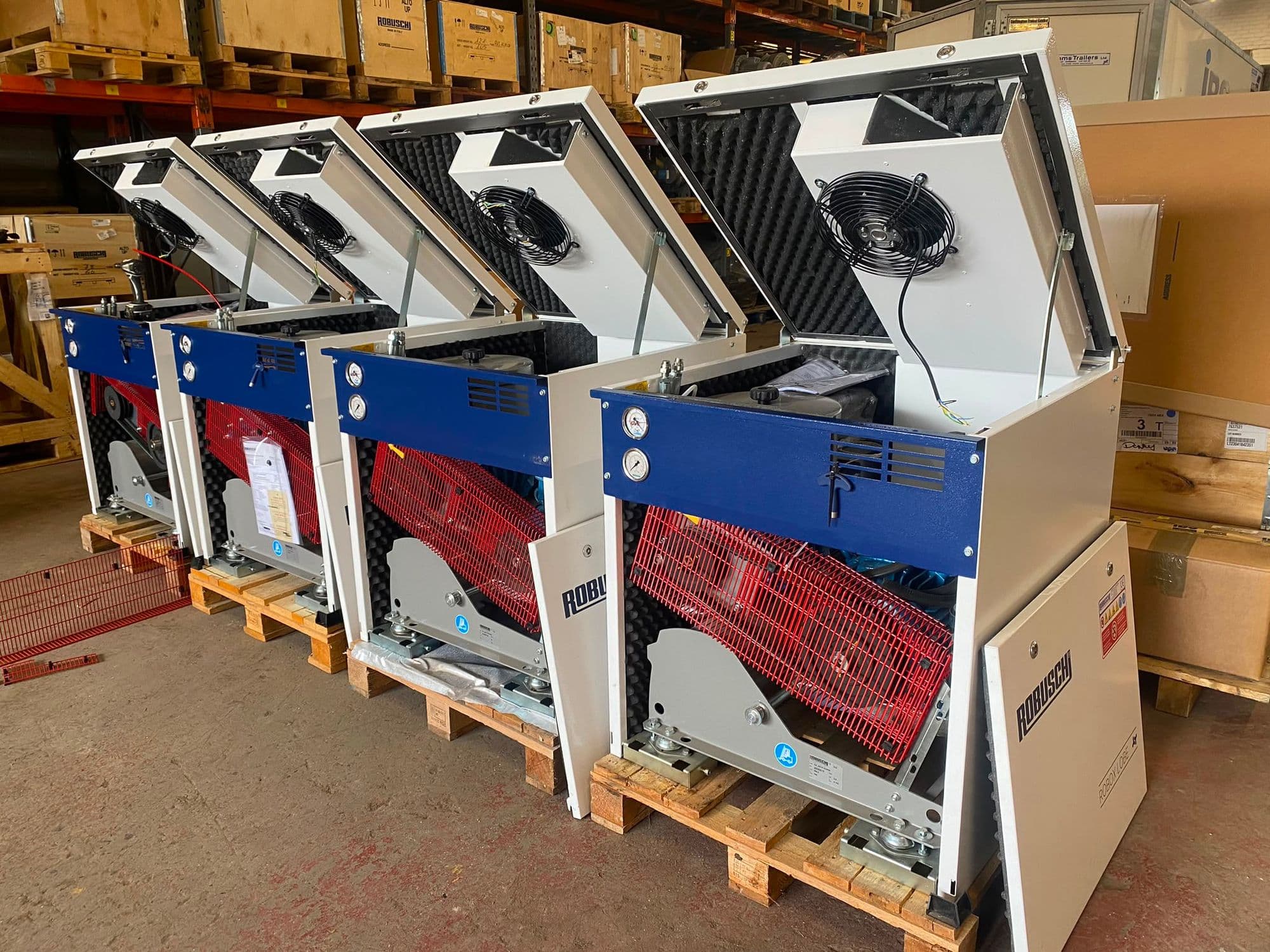 Four new Robuschi Robox packaged blowers with their lids open in the warehouse