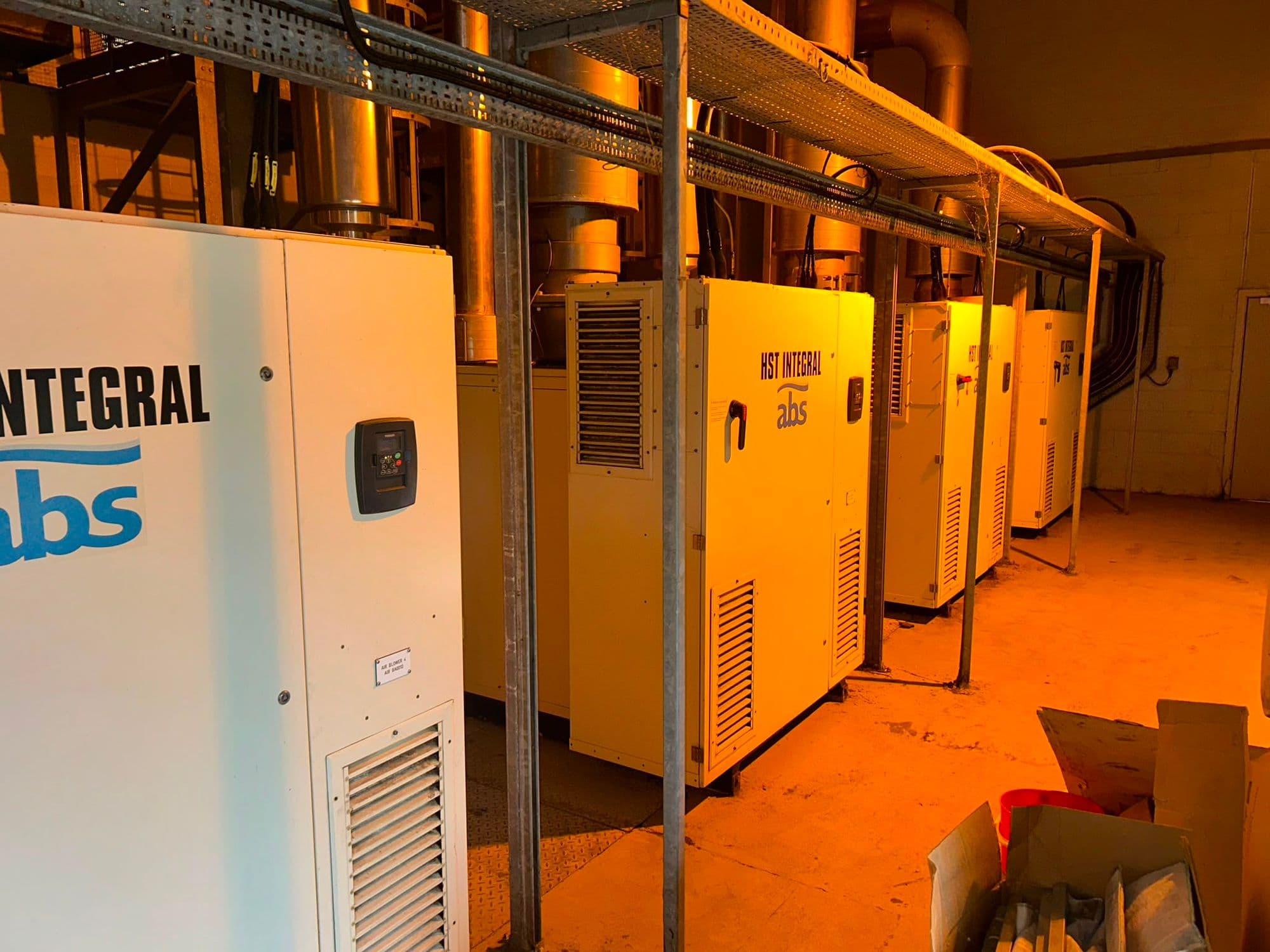 Row of ABS HST turbo blowers in a warm-lit blower house