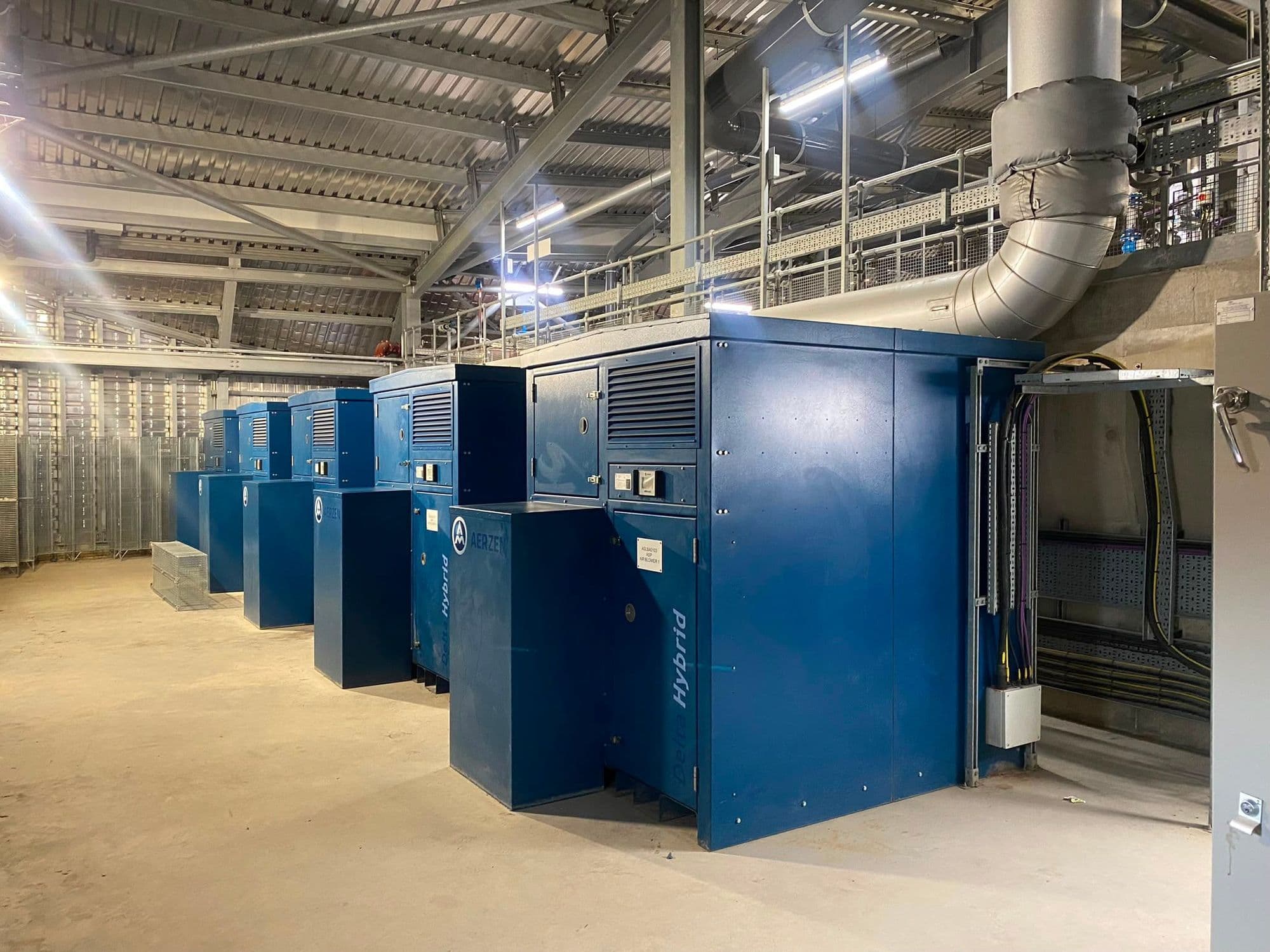 Row of blue packaged blowers receding down a newly built blower hall