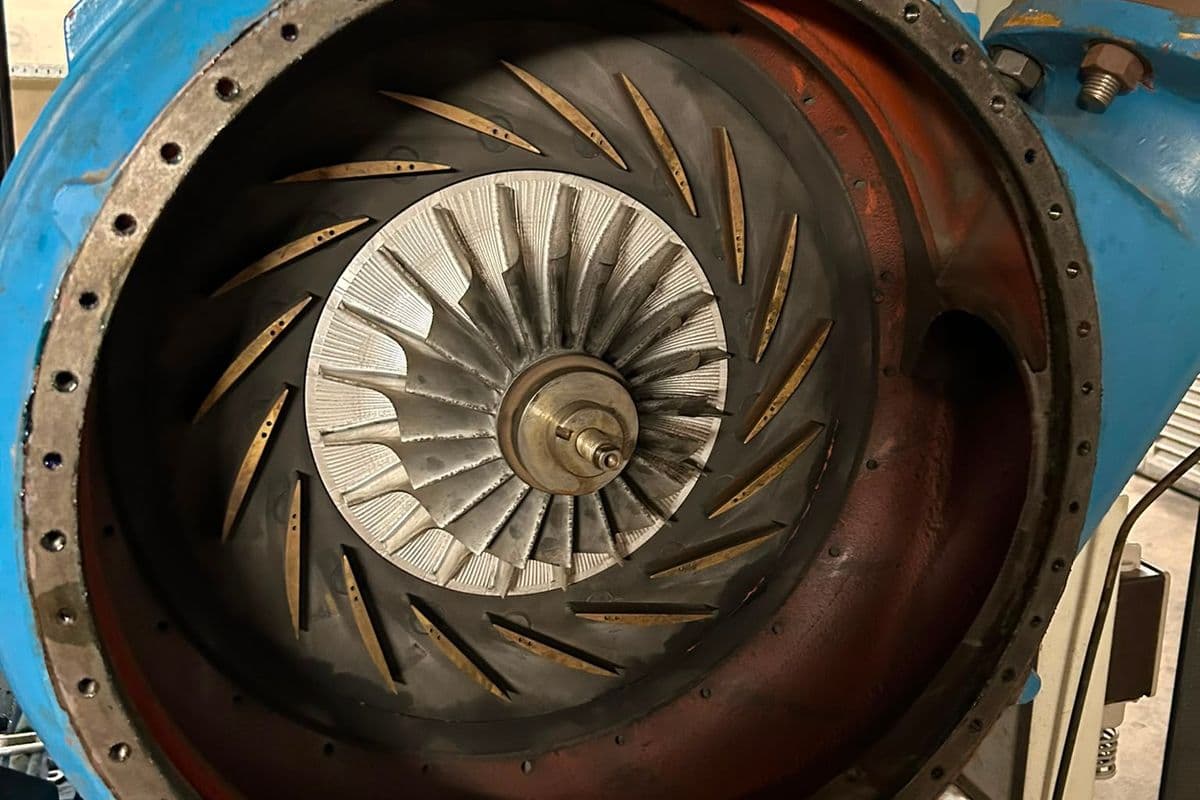 Opened turbo blower casing showing the aluminium impeller and brass diffuser vanes