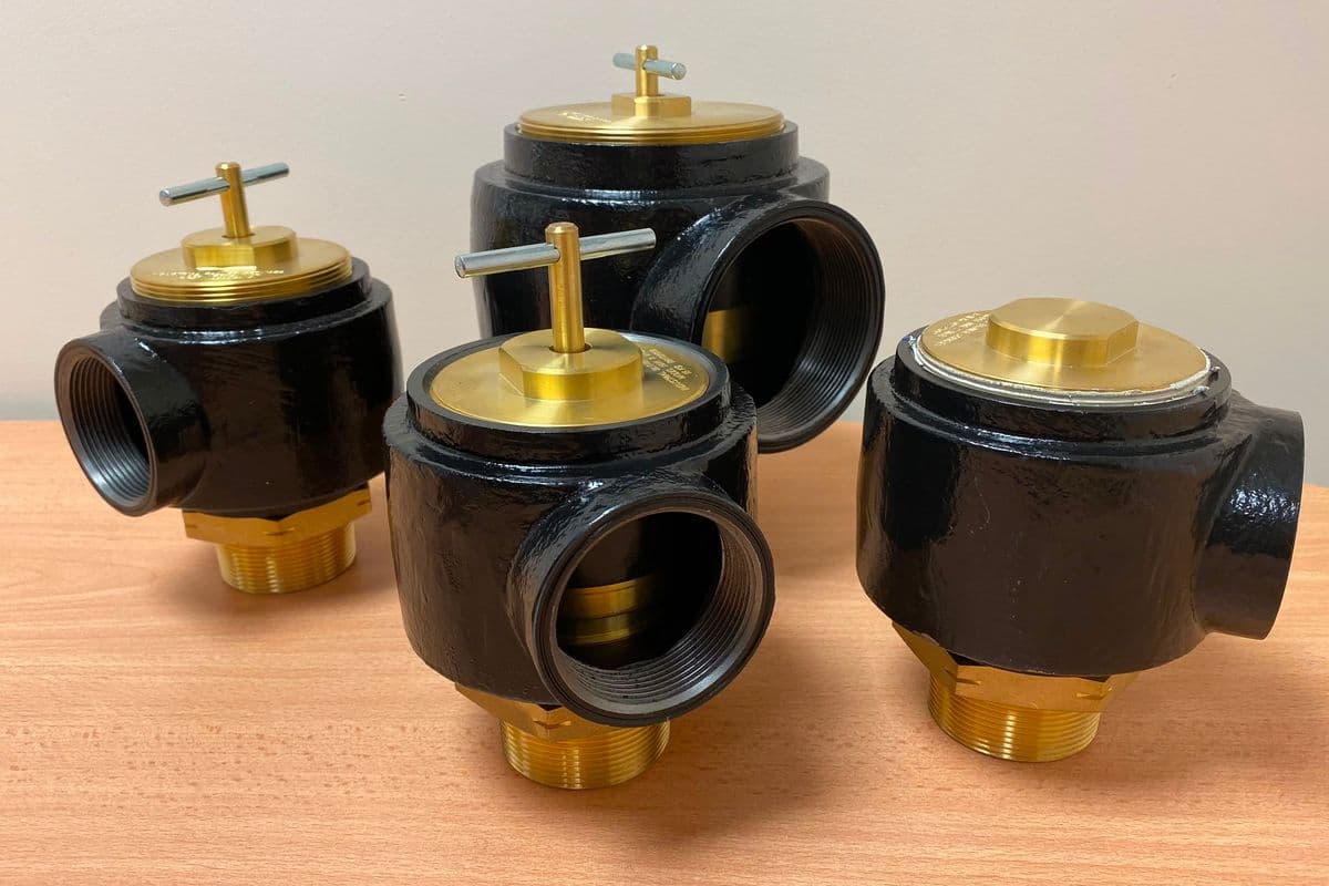 Four new cast relief valves with brass caps grouped on a desk